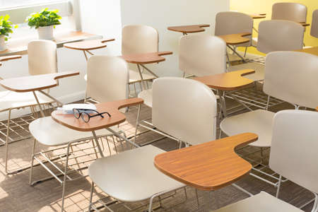 Glasses, pen and notebook on the shelf of Light Brown Office Chairsのeditorial素材