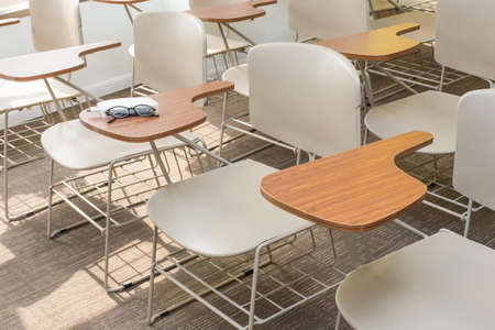 Glasses, pen and notebook on the shelf of Light Brown Office Chairsのeditorial素材