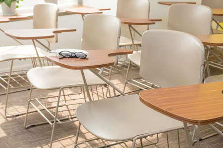 Glasses, pen and notebook on the shelf of Light Brown Office Chairsのeditorial素材