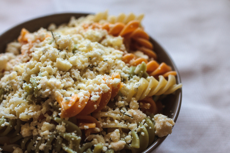 Tri color fusilli with cheese with dill in a grey bowlの写真素材
