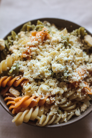 Tri color fusilli with cheese with dill in a grey bowlの写真素材