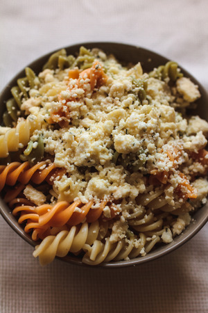 Tri color fusilli with cheese with dill in a grey bowlの写真素材