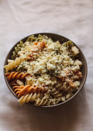 Tri color fusilli with cheese with dill in a grey bowlの写真素材