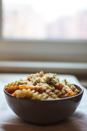 Tri color fusilli with cheese with dill in a grey bowlの写真素材