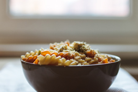 Tri color fusilli with cheese with dill in a grey bowlの写真素材