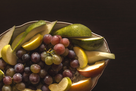 Plate of grapes and sliced apple and pearsの写真素材