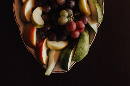 Plate of grapes and sliced apple and pearsの写真素材