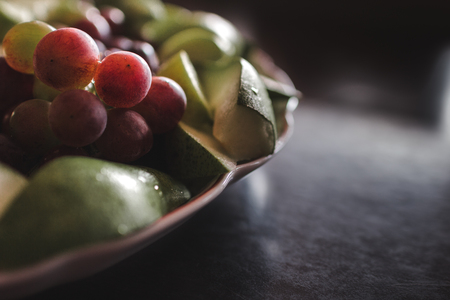 Plate of grapes and sliced apple and pearsの写真素材