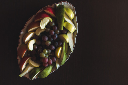 Plate of grapes and sliced apple and pearsの写真素材