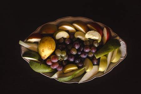 Plate of grapes and sliced apple and pearsの写真素材