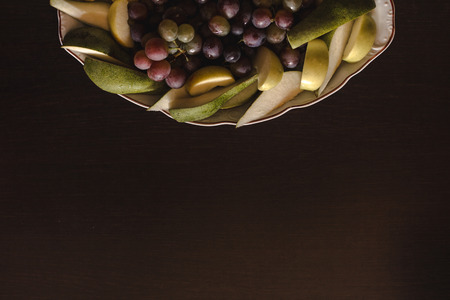 Plate of grapes and sliced apple and pearsの写真素材