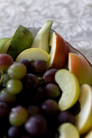 Plate of grapes and sliced apple and pearsの写真素材