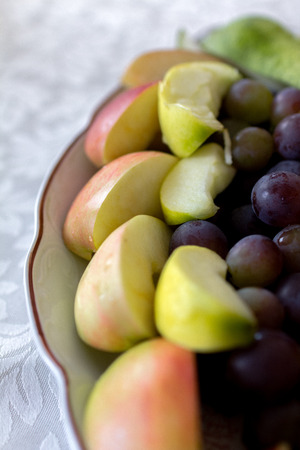 Plate of grapes and sliced apple and pearsの写真素材