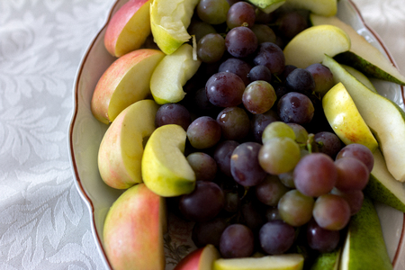 Plate of grapes and sliced apple and pearsの写真素材