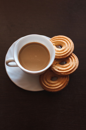 Cup of morning coffee and three round shaped biscuitsの写真素材