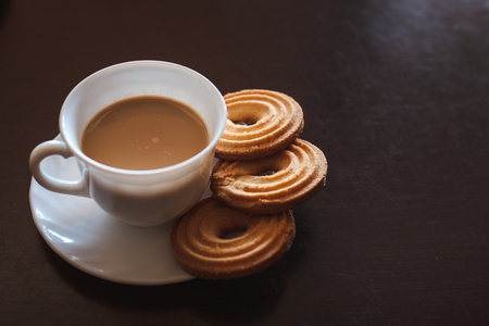Cup of morning coffee and three round shaped biscuitsの写真素材
