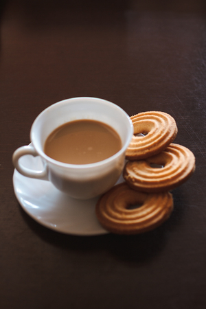 Cup of morning coffee and three round shaped biscuitsの写真素材