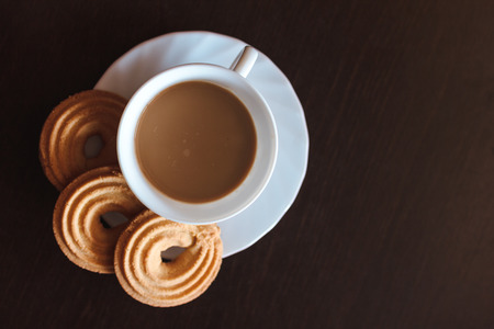 Cup of morning coffee and three round shaped biscuitsの写真素材