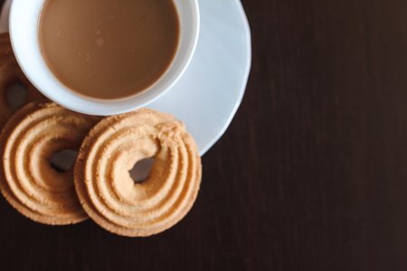 Cup of morning coffee and three round shaped biscuitsの写真素材