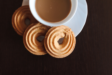 Cup of morning coffee and three round shaped biscuitsの写真素材