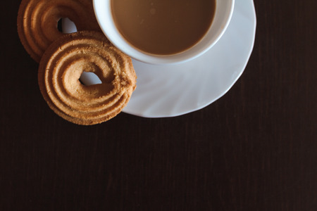 Cup of morning coffee and three round shaped biscuitsの写真素材