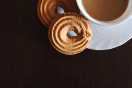 Cup of morning coffee and three round shaped biscuitsの写真素材