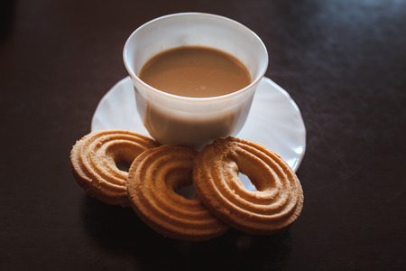 Cup of morning coffee and three round shaped biscuitsの写真素材