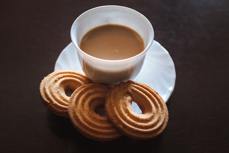 Cup of morning coffee and three round shaped biscuitsの写真素材