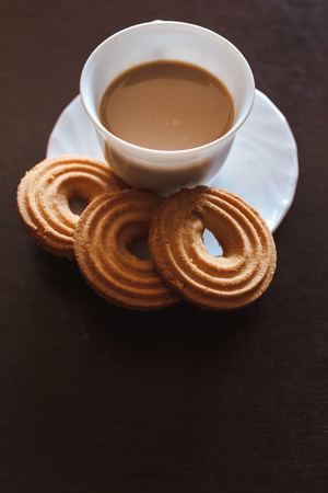 Cup of morning coffee and three round shaped biscuitsの写真素材