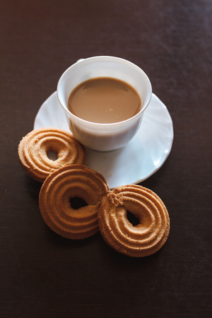 Cup of morning coffee and three round shaped biscuitsの写真素材