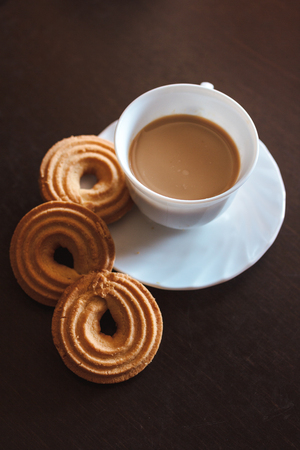 Cup of morning coffee and three round shaped biscuitsの写真素材
