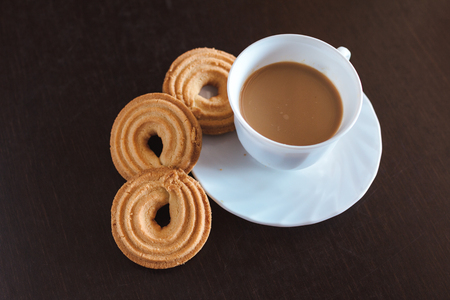 Cup of morning coffee and three round shaped biscuitsの写真素材