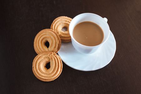Cup of morning coffee and three round shaped biscuitsの写真素材