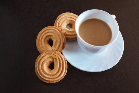 Cup of morning coffee and three round shaped biscuitsの写真素材
