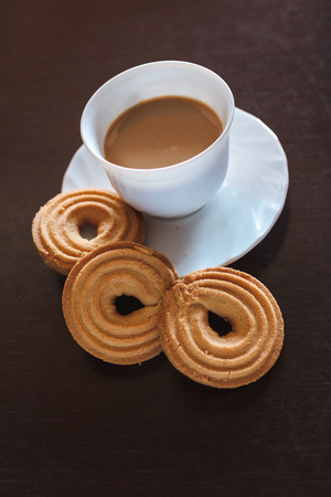 Cup of morning coffee and three round shaped biscuitsの写真素材