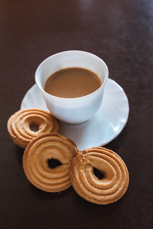 Cup of morning coffee and three round shaped biscuitsの写真素材