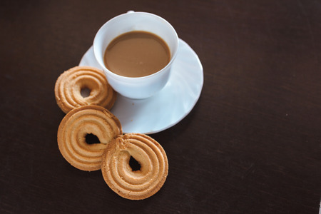 Cup of morning coffee and three round shaped biscuitsの写真素材