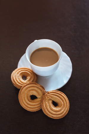 Cup of morning coffee and three round shaped biscuitsの写真素材
