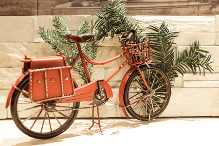 Red decorative bicycle with pine branches in it's basketの写真素材