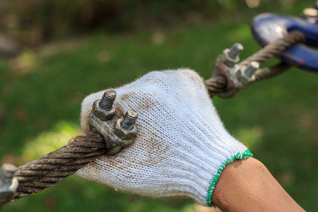 Right hand holding metal sling