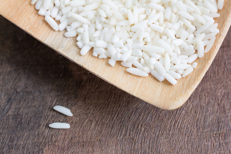 Raw rice in wooden spoonの写真素材