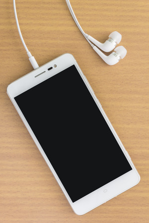 smart phone with earphone on wood tableの写真素材