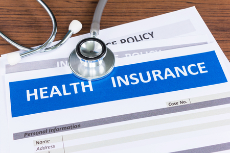 health insurance form with stethoscope in top viewの写真素材
