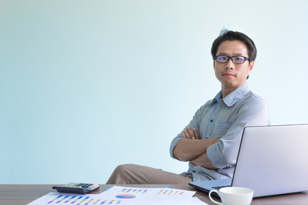 asian businessman sitting in office and crossing his armsの写真素材