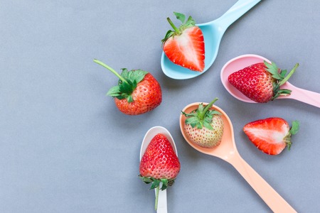 fresh strawberries on plastic spoon in top viewの写真素材