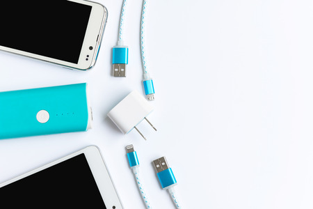 white smartphone with battery bank and usb charging cables in top viewの写真素材