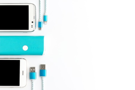 top view of usb charging cable white smartphone and blue battery bank with copy spaceの写真素材