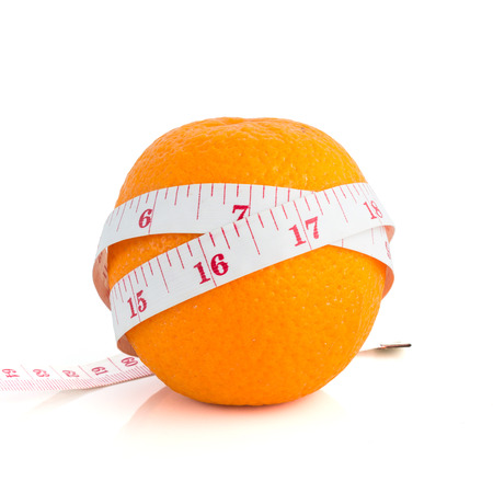 body measuring tape and fresh orange on whiteの写真素材