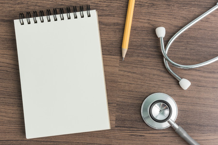 Stethoscope with note book and pencil in top viewの写真素材