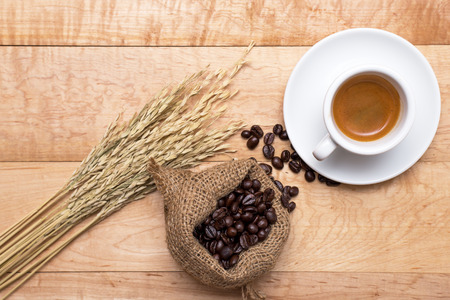 Hot coffee and coffee beans on a wooden tableの写真素材